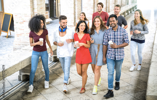 Multiracial friends group walking in city center - Happy guys and girls having fun around old town streets - University students on summer vacations after school end time - Bright daytime filter