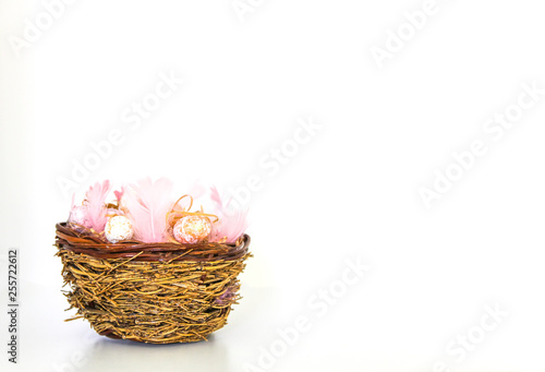 Easter composition with traditional decor. Small decorative colorful eggs and soft feathers on white background.