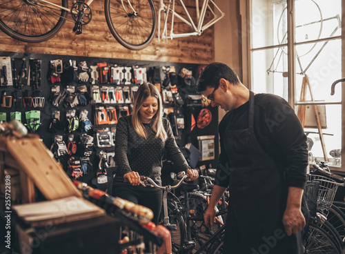 Fototapeta Naklejka Na Ścianę i Meble -  Young woman in bicycle shop.