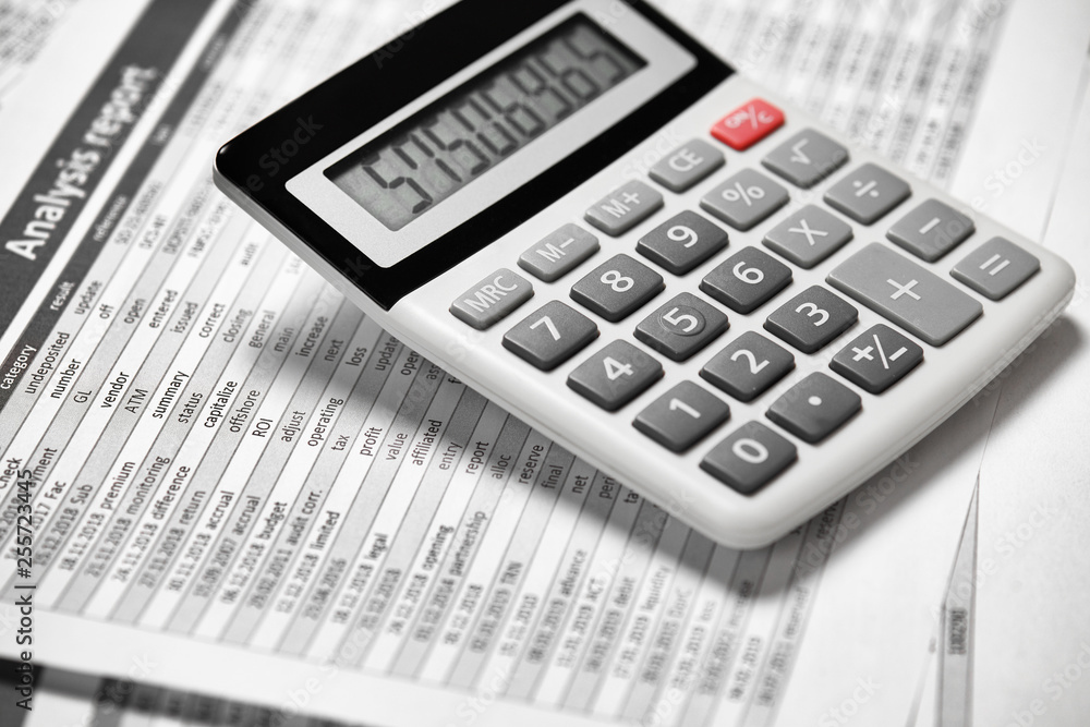 Calculator and reports closeup. Office supplies for working and calculating finance. Business financial accounting concept. Calculator and reports closeup. Office supplies for working and calculating finance. Business financial accounting concept.