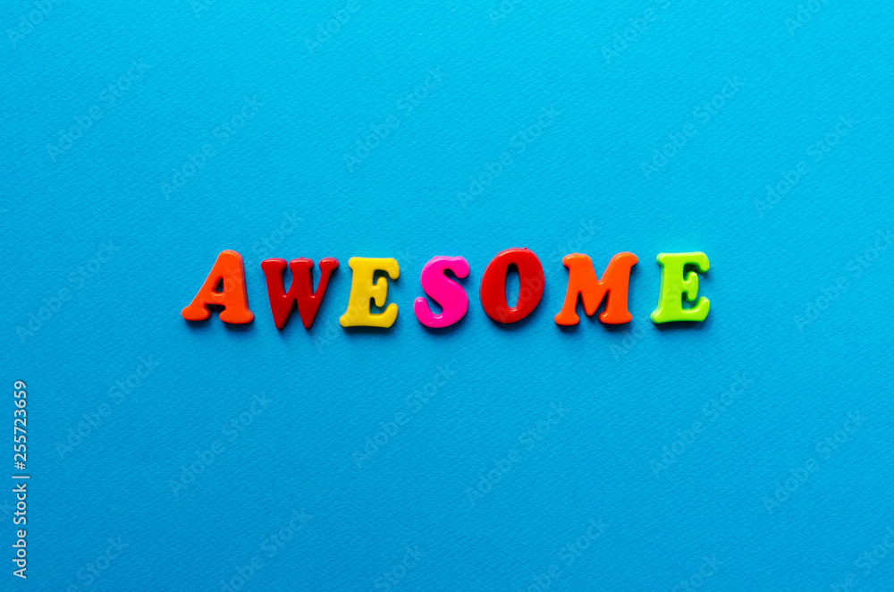 word awesome from plastic magnetic letters on blue background word awesome from plastic magnetic letters on blue background