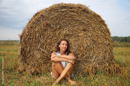 girl in a field on the background of hay