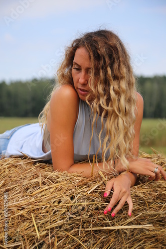girl in a field on the background of hay
