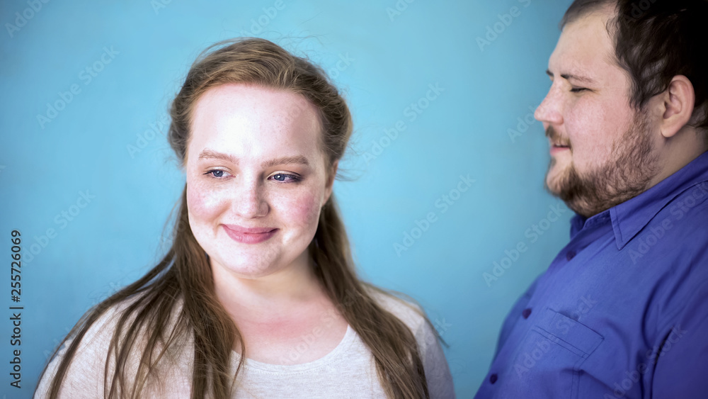 Obese couple feeling happy together, tender relationships, blue background Obese couple feeling happy together, tender relationships, blue background