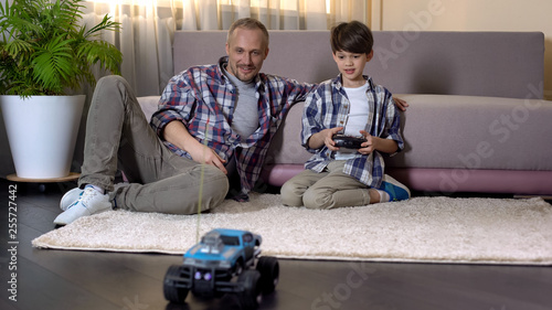 Εκτύπωση καμβά Kid learning to drive car on radio control, expensive gift from sunday father