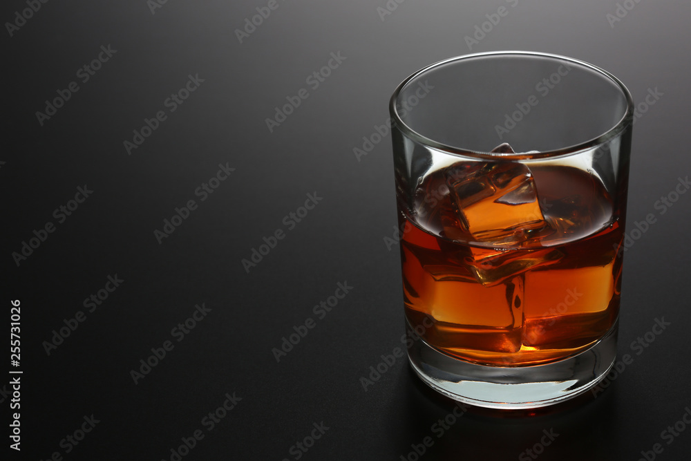 Glass of whiskey on black gradient background