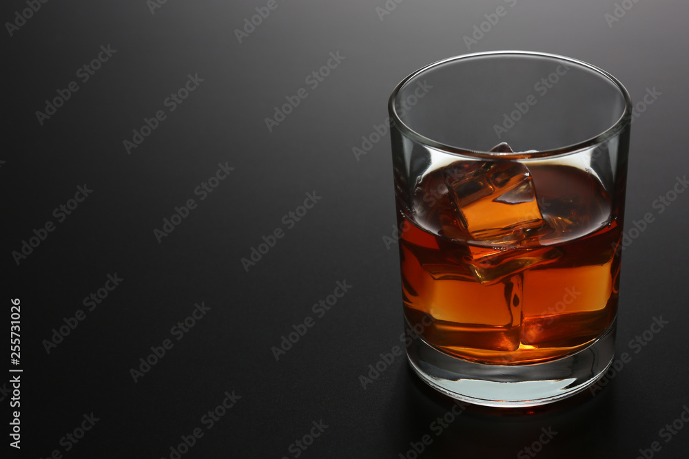 Glass of whiskey on black gradient background Glass of whiskey on black gradient background