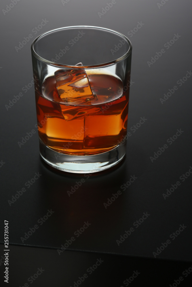 Glass of whiskey on black gradient background