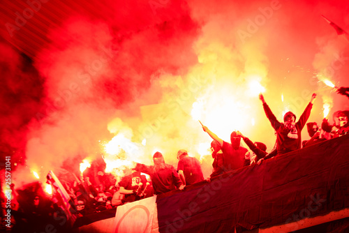 football hooligans with mask holding torches in fire photo