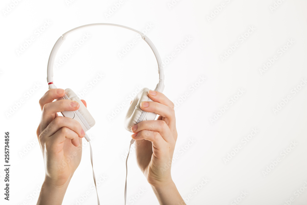 emale hand holding stylish white earphones promoting device emale hand holding stylish white earphones promoting device