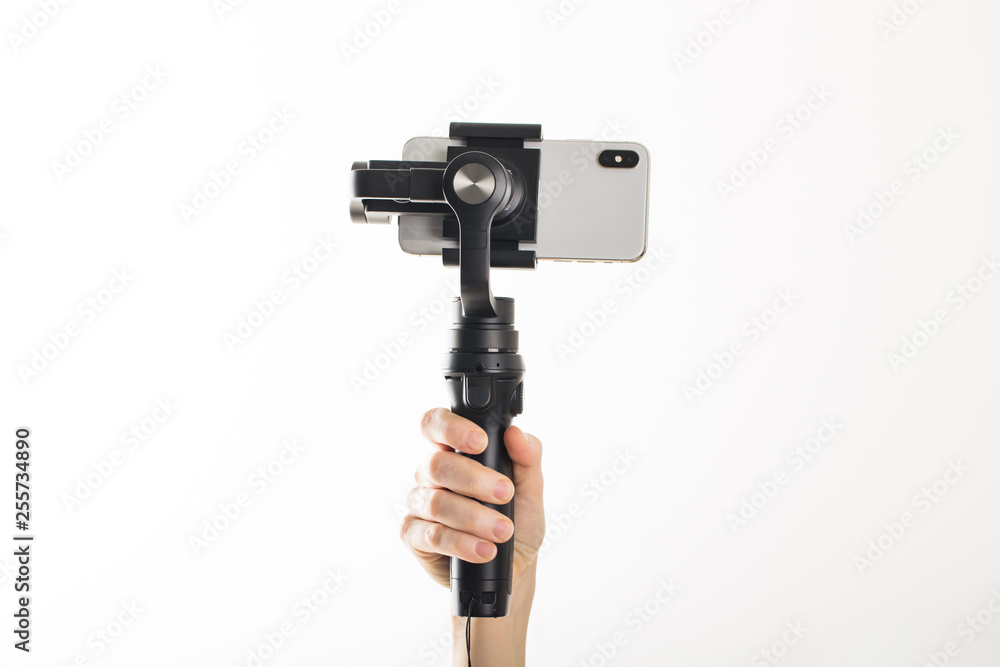 woman hand and gimbal with phone on white background