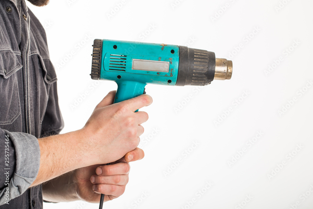 Hand male holding up a heat gun on white Hand male holding up a heat gun on white