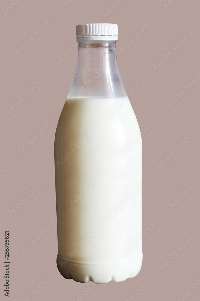 Milk in a glass bottle on brown background Milk in a glass bottle on brown background