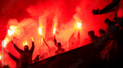 football hooligans with mask holding torches in fire photo