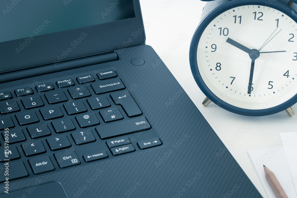 computer and an alarm clock measuring the time running away. The concept of urgent deadlines at work and commitments computer and an alarm clock measuring the time running away. The concept of urgent deadlines at work and commitments