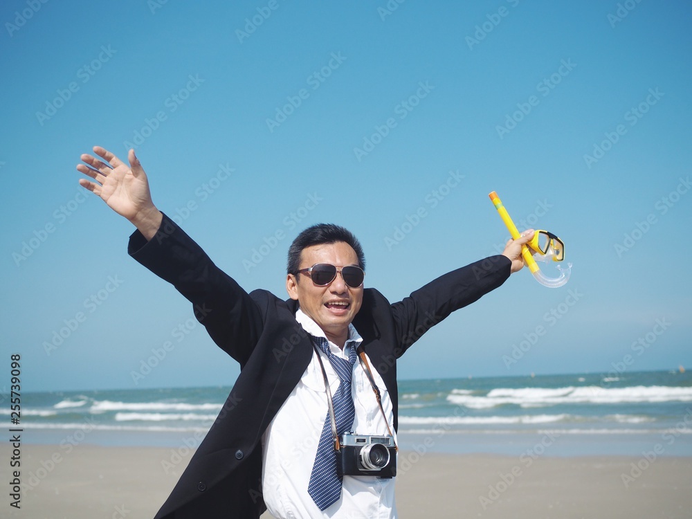 Happy Senior business man standing on the tropical beach,traveler summer concept.