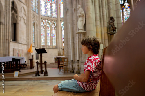 Obraz na płótnie Little boy prays and puts a candle in Orthodox Church.