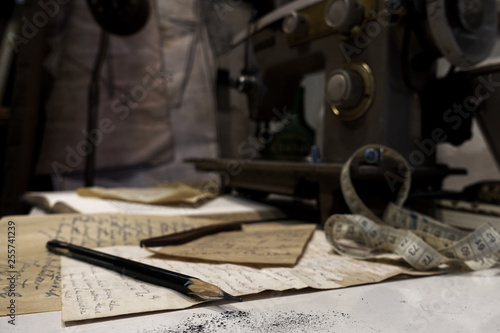Designer pencil on ideas paper with dark background of sewing machine in tailor shop