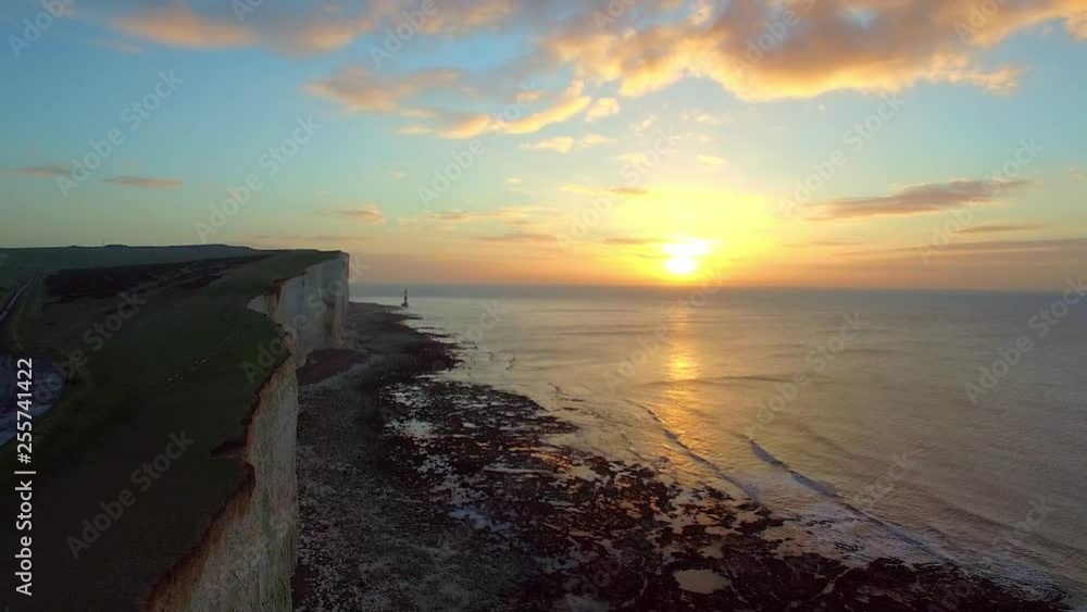 Panoramic view of Seven Sisters cliffs with lighthouse and sea on background at sunrise Panoramic view of Seven Sisters cliffs with lighthouse and sea on background at sunrise