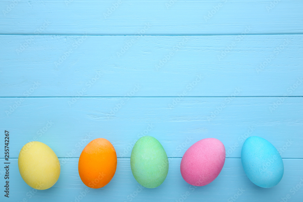 Colorful easter eggs on a blue background, flat lay Colorful easter eggs on a blue background, flat lay