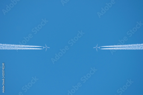 Two aircraft flying towards each other high in the sky.