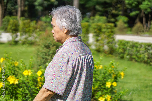 Asian senior or elderly old lady woman smile bright face with strong health while walking at park in holiday 
