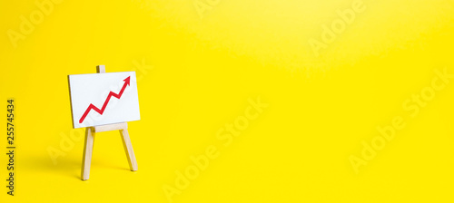 Rack with a red arrow up on a yellow background. Business planning and revenue analysis. Indicators of business projects, level of profitability, liquidity. Increase efficiency, productivity. banner photo