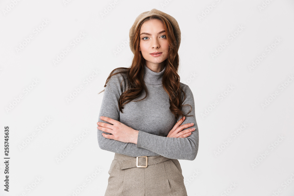 Photo of pretty woman 30s wearing hat standing with arms crossed and looking at you Photo of pretty woman 30s wearing hat standing with arms crossed and looking at you