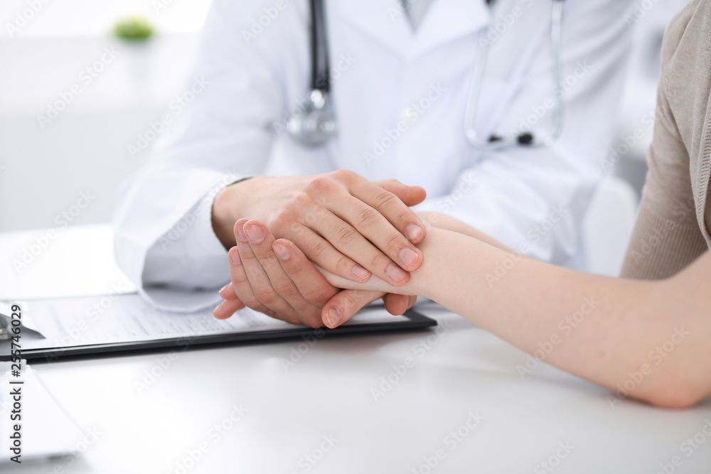 Obraz premium Hand of doctor reassuring her female patient. Medicine and health care concept