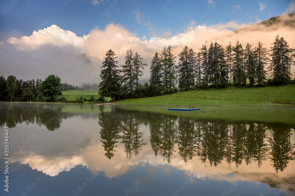 Foggy Morning on lake, with beautiful clouds and reflection Foggy Morning on lake, with beautiful clouds and reflection