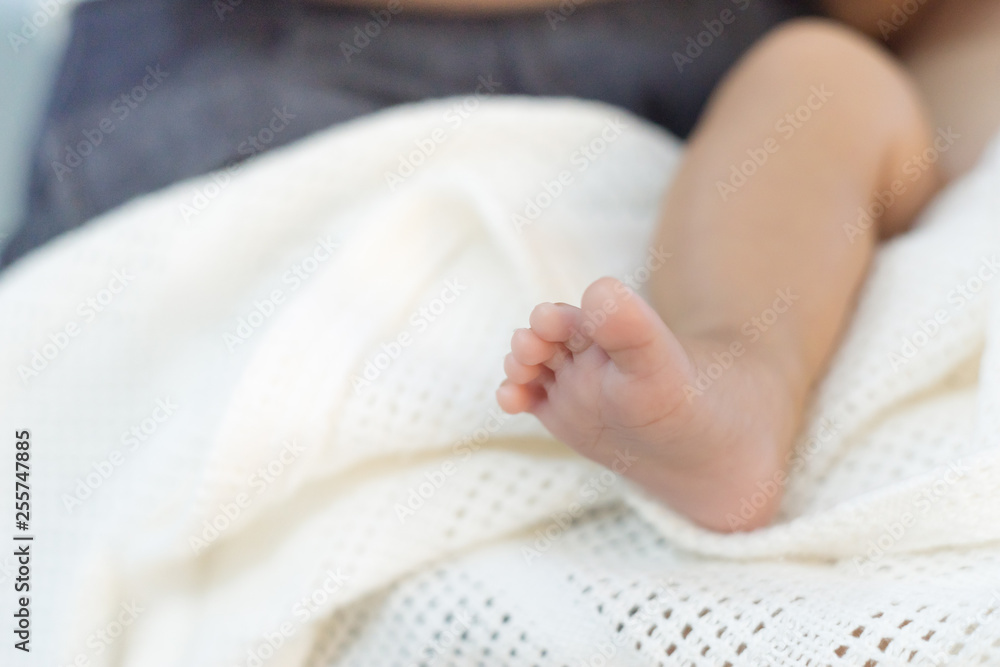 leg and foot of baby on white blanket with copy space for text