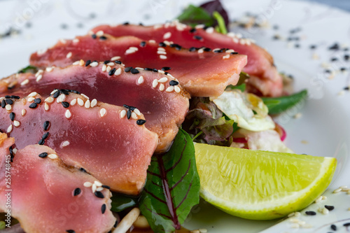 Pieces of a tuna with sesame, moves with a lime in gas station