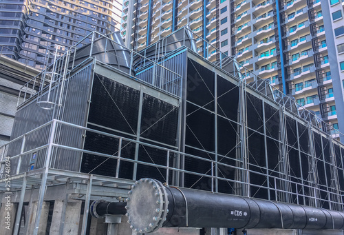 Several cooling towers with a pipe install on the rooftop of building