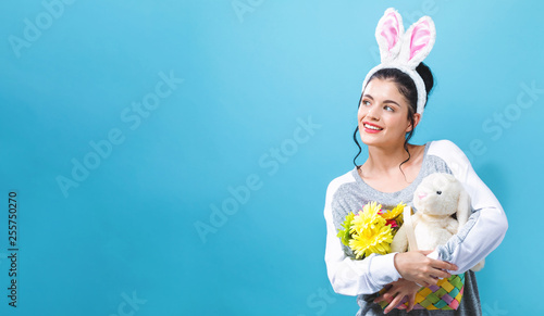 Young woman with an Easter bunny on a blue background