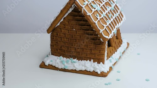 Woman making gingerbread house on white background