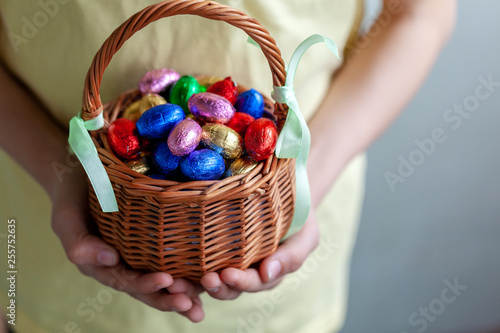 Canvas Print Kids hands holding basket full chocolate easter eggs.