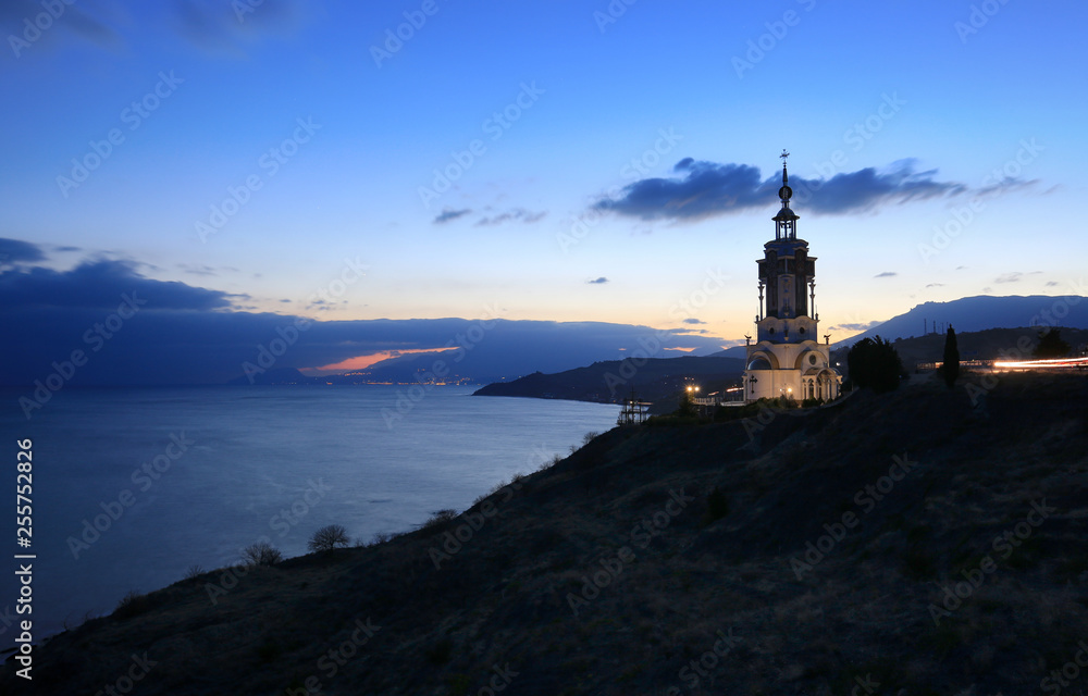 Church-lighthouse of St. Nicholas at sunset on the coast in Crimea