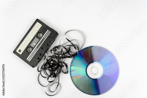 old vintage and compact cassette with the tape sticking out and a compact disc cd
