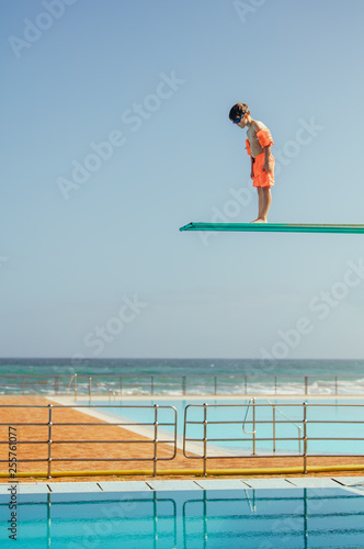 Boy learning to dive at swimming pool