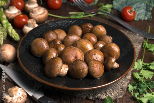 porcelain dish with stewed mushrooms, on classic wooden board