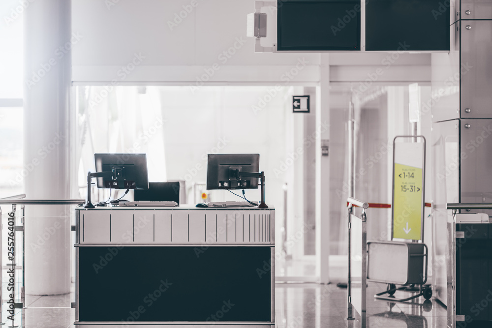 An empty gate of a modern airport terminal with computer monitors on ...