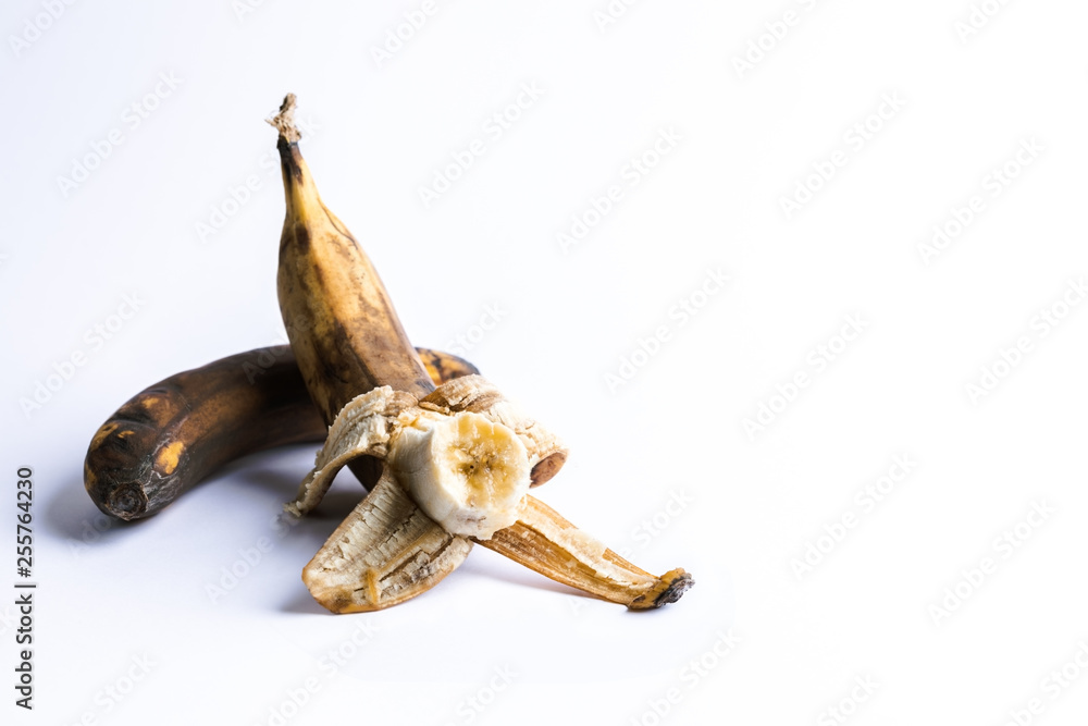 Obraz premium Two overripe blackened ugly bananas on white background.