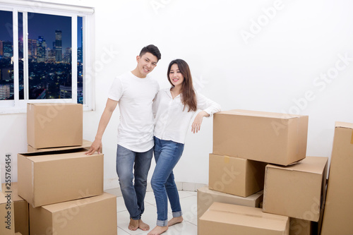Smiling couple with cardboards in the new apartment