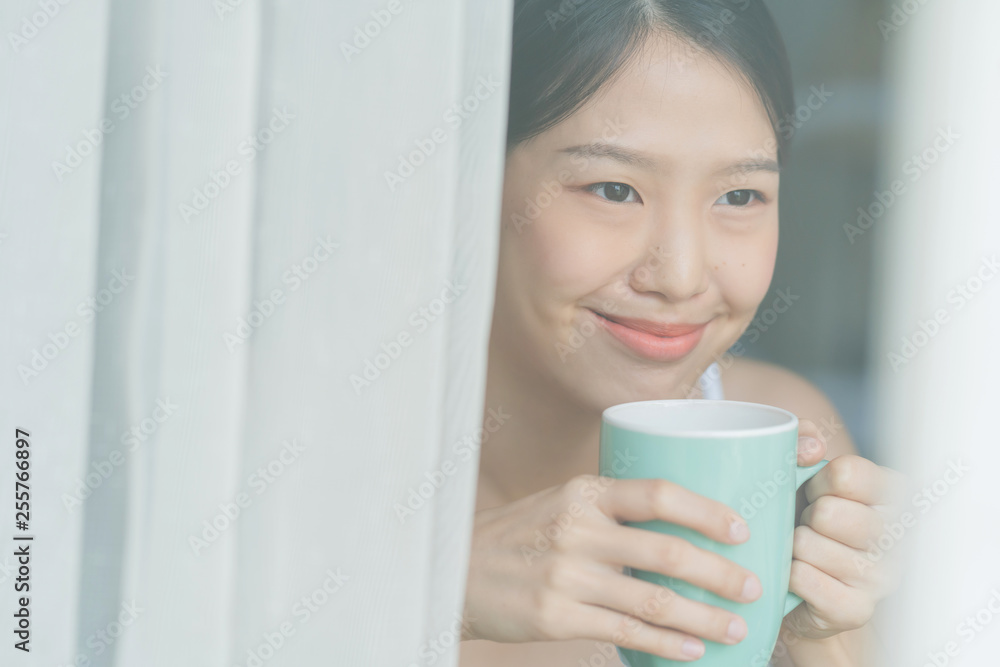 beautiful asian teen white Tank top happiness smile enjoy freshness morning with hot drink near window with sun light beautiful asian teen white Tank top happiness smile enjoy freshness morning with hot drink near window with sun light