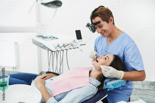 Charming young woman having good mood while visiting dentist