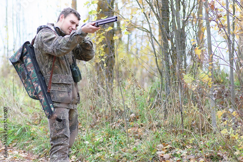 Man in camouflage and with guns in a forest belt on a spring hunt