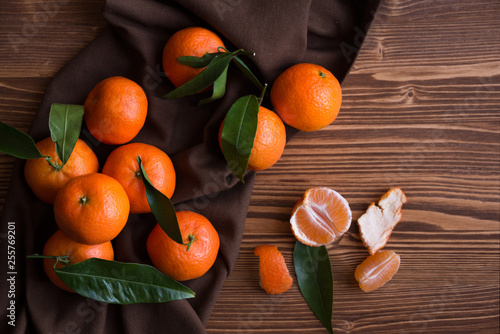 Ripe delicious mandarines with zest on dark wooden table