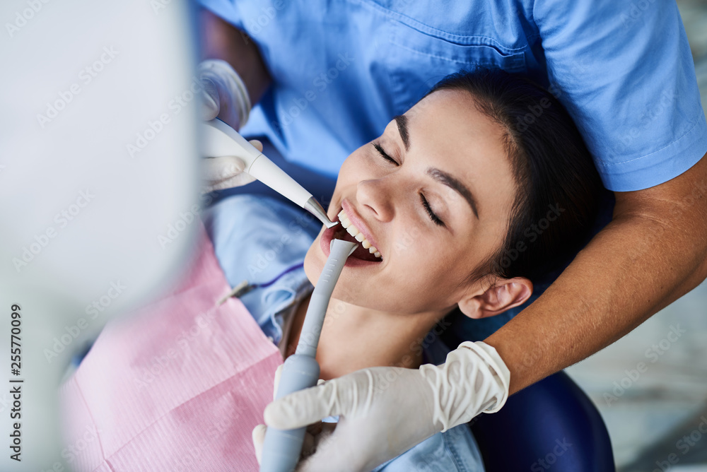 Charming young woman having dental procedure at modern clinic Charming young woman having dental procedure at modern clinic
