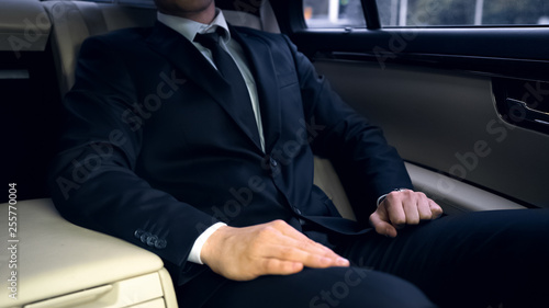 Man in suit sitting on backseat of car, way to work, safety on roads, statistics © motortion