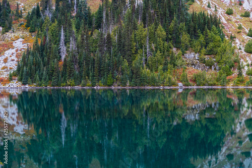 Calm Blue Wates Reflect Trees on mountain Slope photo